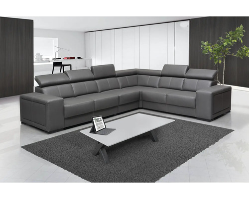 Graues Ecksofa aus Leder in einem hellen Wohnzimmer mit einem weißen Couchtisch.