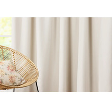 Rideau et fauteuil en rotin avec coussin devant une fenêtre