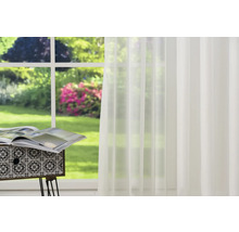 Rideau transparent devant une fenêtre avec vue sur le jardin