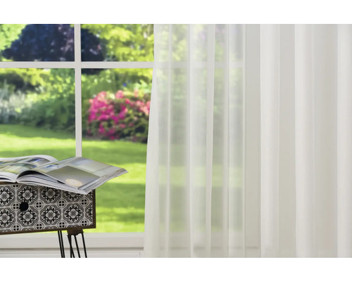 Rideau transparent devant une fenêtre avec vue sur le jardin