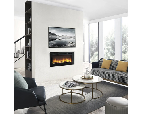 Wohnzimmer mit Elektrokamin, Couch, Sessel und Couchtischen