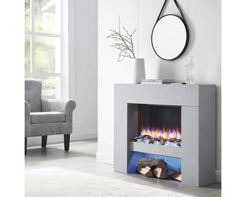 Salon avec cheminée électrique, fauteuil et miroir rond