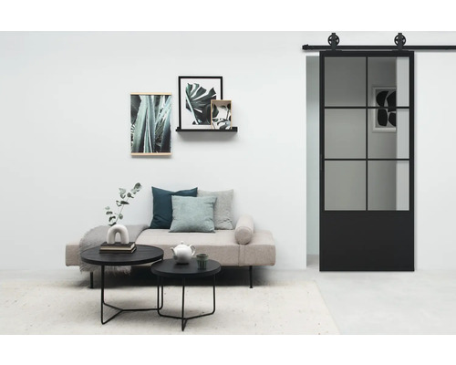 Wohnzimmer mit Tagesbett, runden Tischen, Wanddekoration und Schiebetür