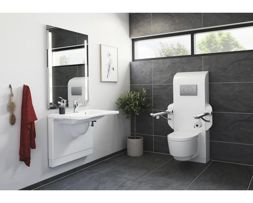Salle de bain accessible avec lavabo, miroir et WC avec barres d''appui.