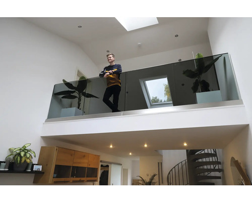 Helles Wohnzimmer mit Galerie, Glasgeländer und Zimmerpflanzen