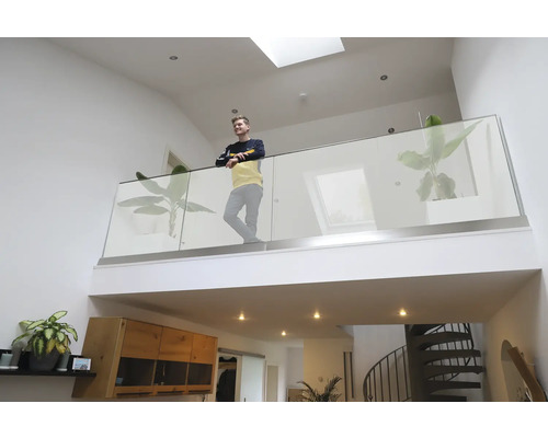 Heller Wohnraum mit Galerie, Glasgeländer und Wendeltreppe