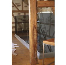 Photo d''intérieur d''une maison avec pilier en bois et garde-corps en verre.