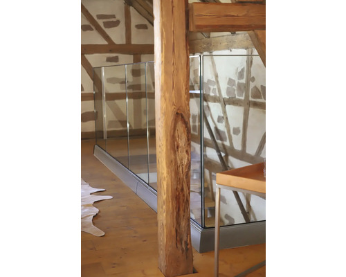 Intérieur avec pilier de support en bois et garde-corps en verre.