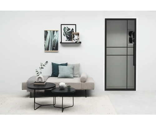 Helles Wohnzimmer mit Tür, Sofa, Couchtisch und Dekoration