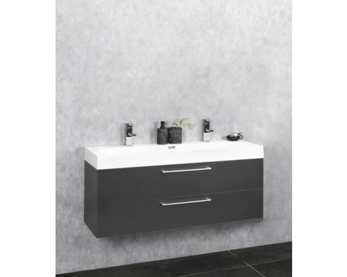 Meuble sous-lavabo avec deux tiroirs, robinetterie et objets de décoration dans la salle de bains.