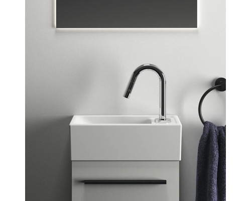 Kleiner Waschtisch mit Armatur und Handtuchring im Badezimmer