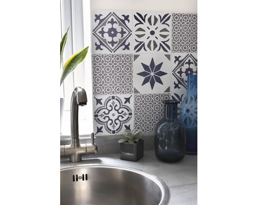 Évier avec robinet devant un mur avec des carreaux décoratifs dans un espace cuisine.