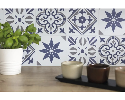 Mur de carreaux décoratifs avec motif floral et plante en pot