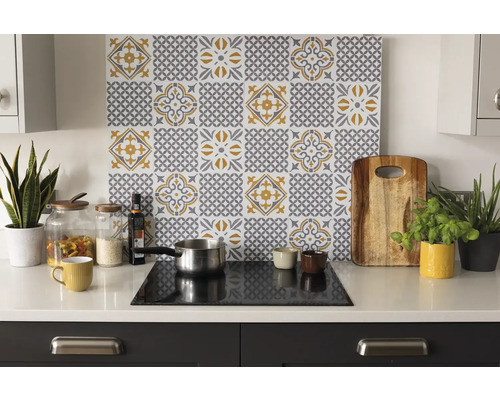 Scène de cuisine avec crédence à motif de carreaux jaunes et gris au-dessus de la plaque de cuisson