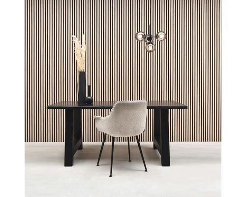 Esszimmer mit Esstisch, Stuhl und Dekoration vor einer Wandverkleidung.