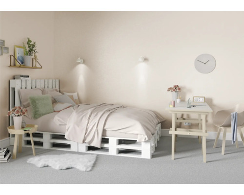 Schlafzimmer mit Bett aus Holzpaletten, Schreibtisch und Stuhl