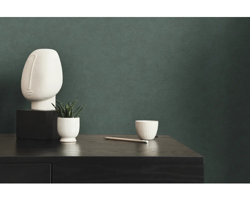 Dekorative Szene mit Kunstkopf, Pflanze, Tasse und Bleistift auf einer Kommode.