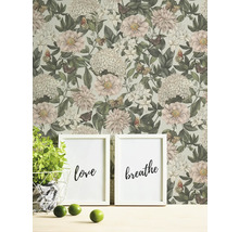 Wohnszene mit Blumentapete, zwei gerahmten Bildern mit den Aufschriften Liebe und Atmen, Topfpflanze und Limetten