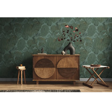 Wohnzimmer mit grüner Blättertapete, Holzkommode und Hockern