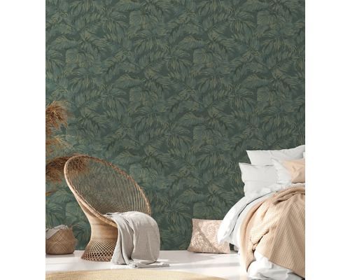 Chambre avec papier peint à feuilles tropicales, lit et fauteuil en rotin