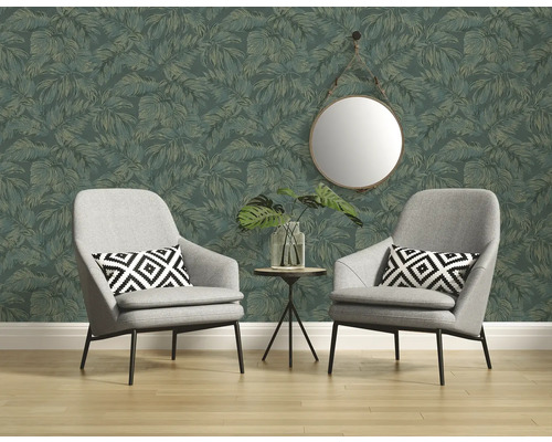 Deux fauteuils devant un mur avec du papier peint à motifs de feuilles, au-dessus un miroir rond