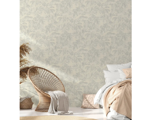 Helles Schlafzimmer mit Blättertapete, Korbsessel und Bett