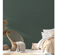 Helles Schlafzimmer mit Bett, Rattansessel und Dekoration