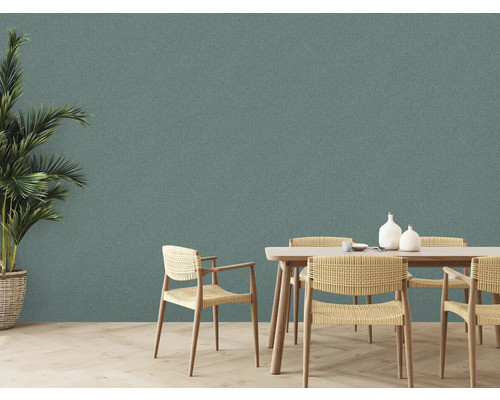 Une salle à manger lumineuse avec une table à manger, des chaises et une plante d''intérieur devant un mur texturé