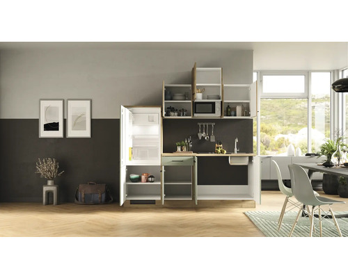 Cuisine équipée complète avec réfrigérateur, évier, micro-ondes et armoires dans un design de cuisine clair et moderne.