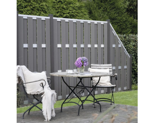 Jardin avec clôture en bois et coin salon avec table et chaises