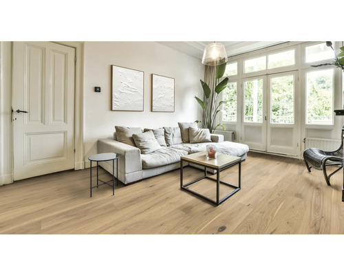 Wohnzimmer mit Sofa, Tisch und hellem Holzboden