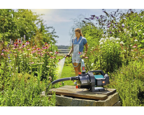 Garten Szene mit einer Frau, die Pflanzen gießt, und einer Wasserpumpe von Gardena