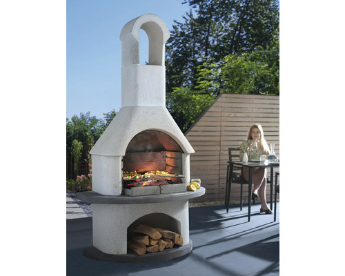 Gemauerter Gartengrill mit Holzfach und Speisen auf dem Rost