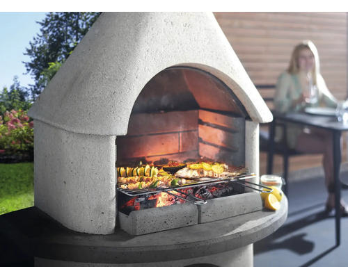 Gemauerter Grill mit Speisen auf dem Grillrost in einer Gartenszene