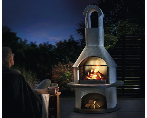 Aussenkamin aus Stein mit Feuer und Holz unter freiem Himmel