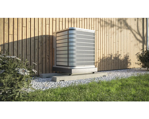 Außenklimaanlage auf Betonsockel vor einer Holzwand