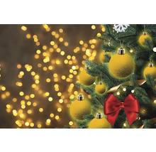 Arbre de Noël décoré avec des boules et un nœud sur fond bokeh