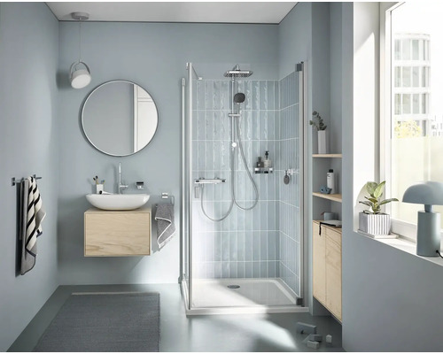 Badezimmer mit Dusche, Waschbecken, Spiegel und Handtüchern