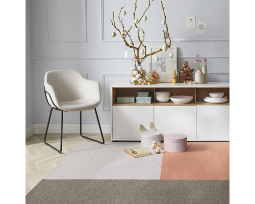 Salon décoratif avec fauteuil, tapis et décorations de Pâques sur un buffet