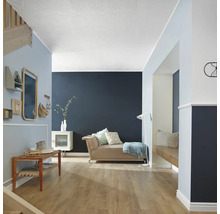 Espace de vie avec canapé, étagères, miroir et plancher en bois.