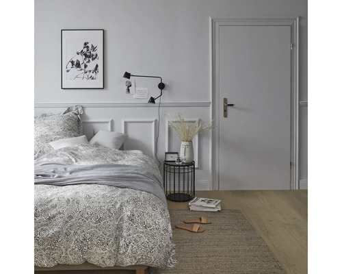 Schlafzimmer mit Bett, Nachttisch, Lampe und Dekoration