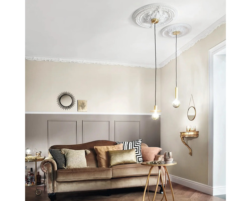 Wohnzimmer mit Sofa, Beistelltisch und Pendelleuchten unter Stuckrosetten