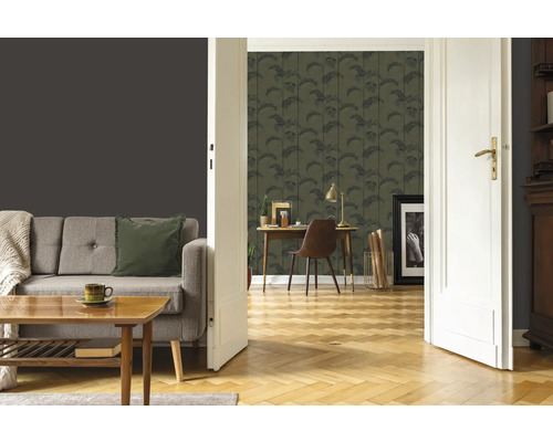 Wohnzimmer mit Sofa, Tisch und Arbeitszimmer mit Schreibtisch und gemusterter Tapete