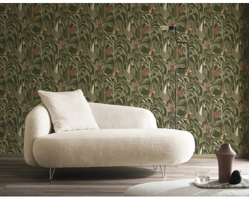 Szene mit einem Sofa vor einer Wand mit Blättermuster-Tapete, ergänzt durch eine Stehlampe.