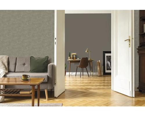 Wohnzimmer mit grauer Vliestapete an der Wand, Sofa und Holztisch