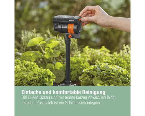 GARDENA Vielflächenregner mit Hand im Gartenbeet