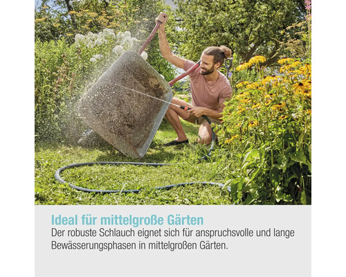 Un homme arrose un grand pot de fleurs dans le jardin avec un tuyau d''arrosage