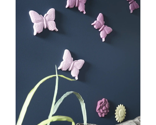 Wanddekoration mit Schmetterlings- und Blumenmotiven an einer blauen Wand