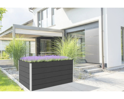 Grosses, rechteckiges Hochbeet aus Holz mit Pflanzen vor einem Wohnhaus.