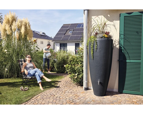 Scène de jardin avec récupérateur d''eau, homme arrosant et femme dans une chaise longue